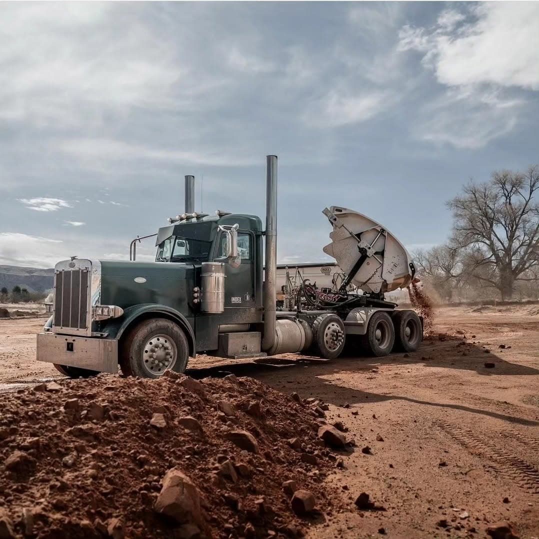 SmithCo side dump trailer unloading aggregate at a Western Truck & Trailer job site